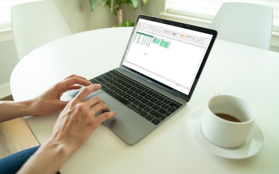 Secretária com um computador com uma folha de Excel com uma segmentação de dados