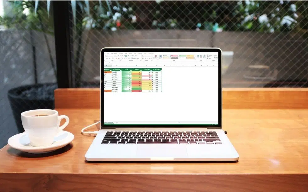 Secretária com computador com Excel com uma tabela personalizada com formatação condicional